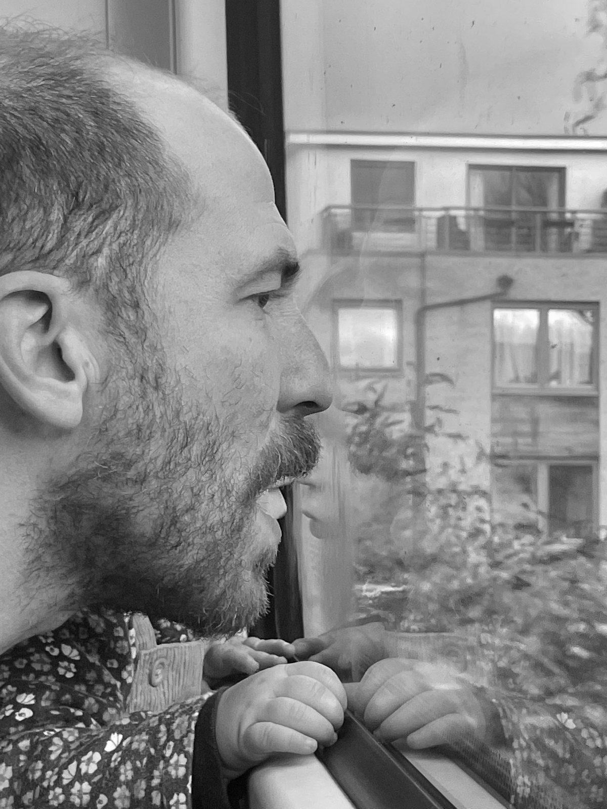 Johnny Clarke, in profile at a window, face to face with his own reflection